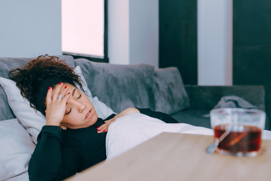 Zieke vrouw op de bank met thee - Canva Pro Zieke vrouw op de bank met thee